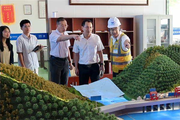 卓豪（右2）在邁灣水利工程審計中查看沙盤